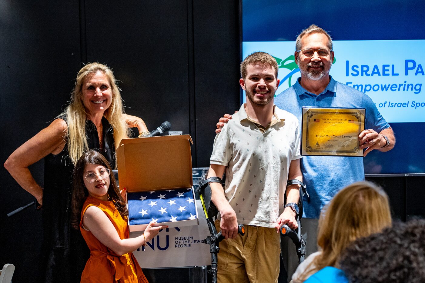 Adam Zborovsky and Lisa Roth present flag flown in Washington DC alongside US National Board President Jon Michelon